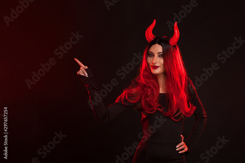 Leinwand Poster Image of Halloween makeup look of beautiful demon on dark background with copyspace