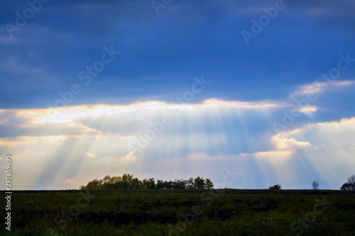 Landscape with a beautiful sky and rays of sunshine penetrating through dark cloud_
