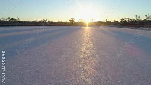 Aerial pan low across beautiful shining salt lake surface facing the sun at sunset photo