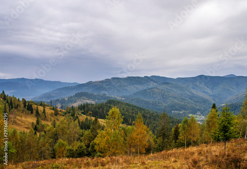 Beautiful autumn mountain forest landscape. Clouds over the rocks.