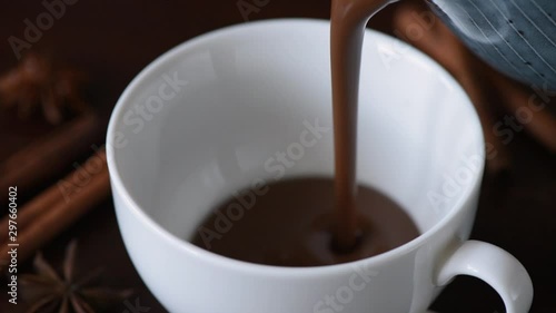 Pouring hot chocolate in cup slow motion closeup view