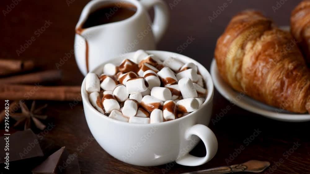 Hot chocolate with marshmallows and chocolate syrup in white cup. Cozy comfort food, Christmas concept Hot chocolate with marshmallows and chocolate syrup in white cup. Cozy comfort food, Christmas concept