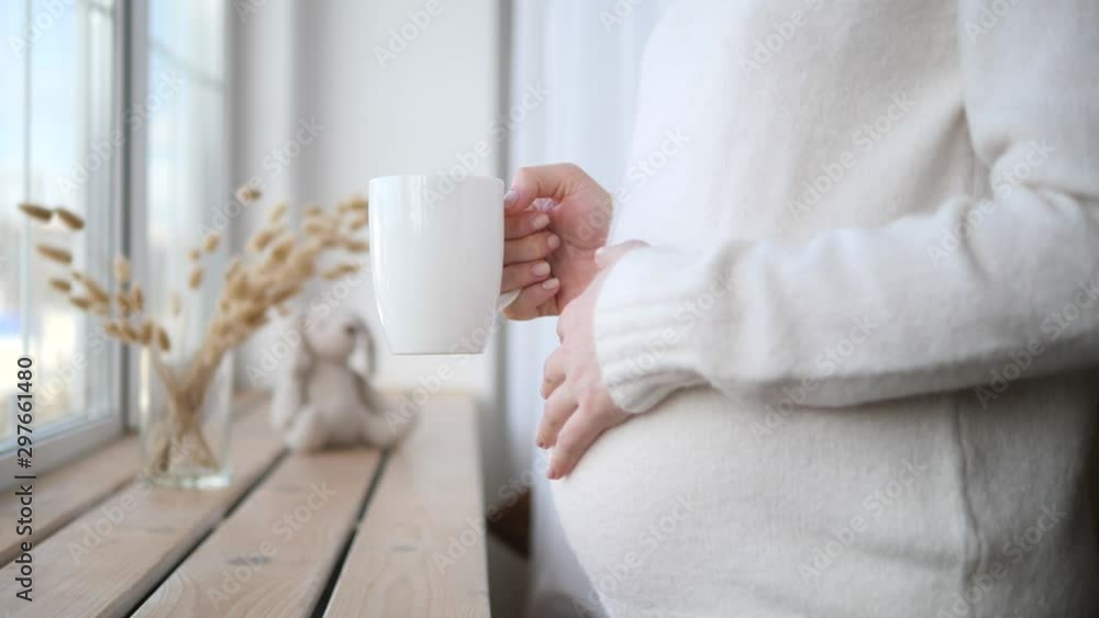 Closeup Of Pregnant Woman With Cup Drinking Tea In The Morning Closeup Of Pregnant Woman With Cup Drinking Tea In The Morning