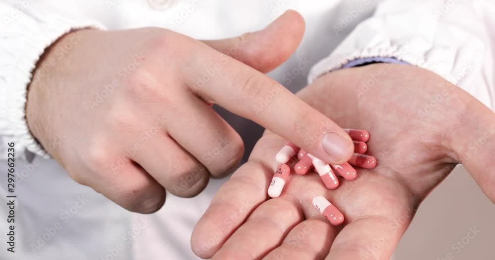 Mani di un medico mentre conta le pillole Mani di un medico mentre conta le pillole