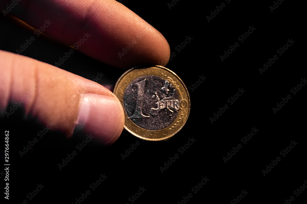 euro coin in hand with black background euro coin in hand with black background