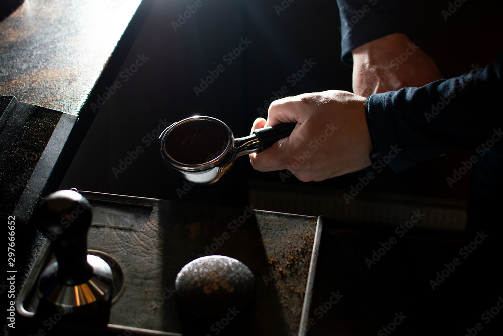 process of making coffee, the barista presses ground beans, the guy makes coffee in a coffee shop