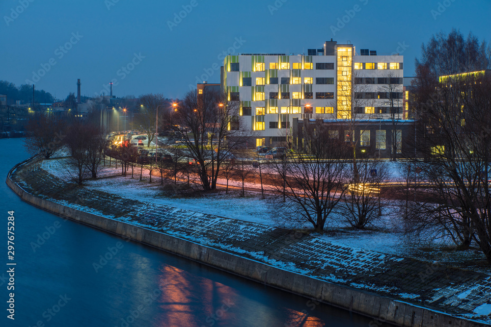 Modern design of the building. Modern architecture. Snow on the ground.