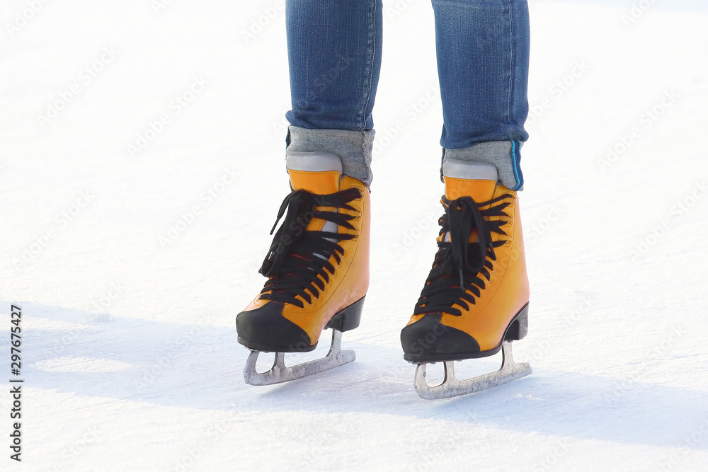 feet in red skates on an ice rink. Sport and entertainment. Rest and winter holidays. feet in red skates on an ice rink. Sport and entertainment. Rest and winter holidays.