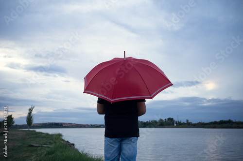 boy with red umbrella from behind on the river bank © FranciscoJavier