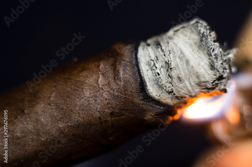 close up of a Cuban cigar being lit with a flame 