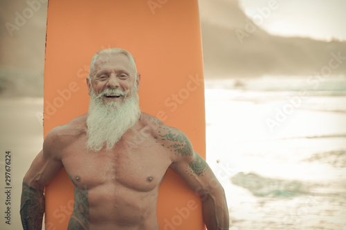 Senior man with orange longboard. Happy old guy having fun doing extreme sport. Joyful elderly concept - Image