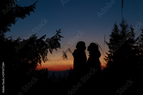 Silhouette of lesbian girls. Sunset. Autumn Carpathians in Ukraine. Travel.
