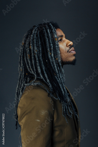 Vertical profile portrait of a young man with cool hair looking up in studio © Carlos David