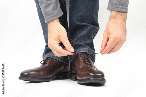Man tying shoelaces on classic brown shoes