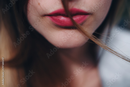 Close up portrait of part of caucasian woman face.  Thin woman lips with red lipstick on it. Concept of fashion and face.