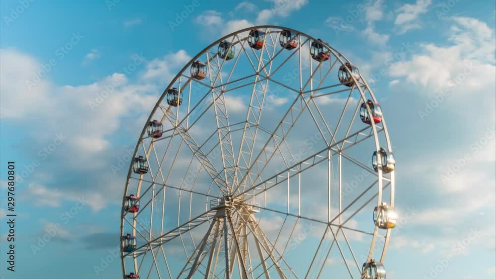 Timelapse of clouds movement and rotating ferris wheel at festival or carnival. Summer cloudy day, warm illumination, sunset sky. Time lapse, sightseeing, cityscape, entertainment, holiday concept