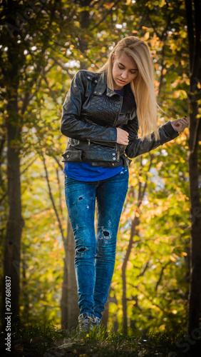Girl blonde stands in the park in full growth.