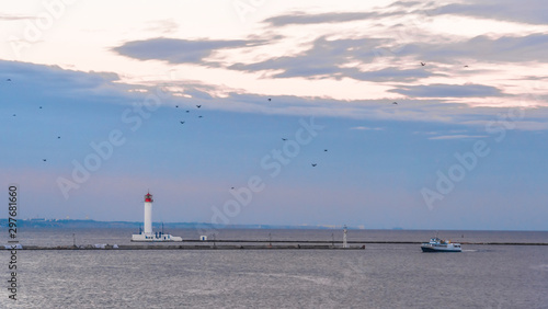 White Vorontsov lighthouse in the sunset sky with seagulls.