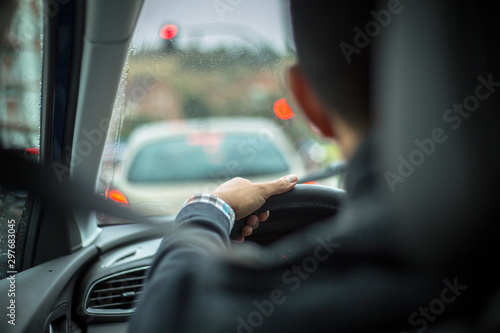 man driving a car in the rain