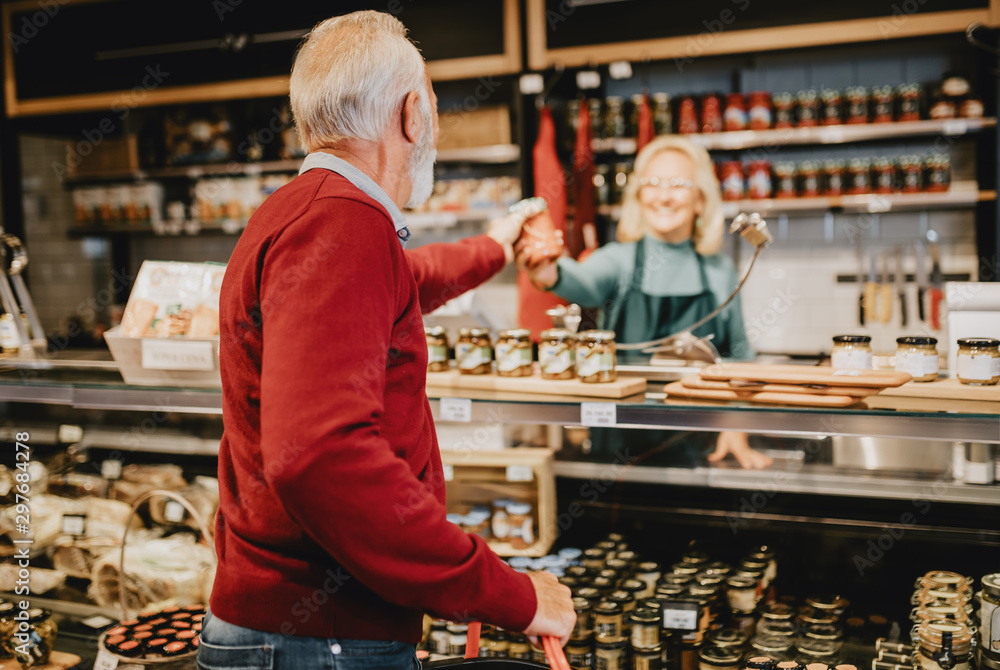 Happy senior man shopping in grocery store or supermarket. Consumerism concept. Happy senior man shopping in grocery store or supermarket. Consumerism concept.