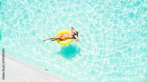 Aerial view of attractive woman in swimsuit in the yellow rubber ring in the swimming pool © F8  \ Suport Ukraine