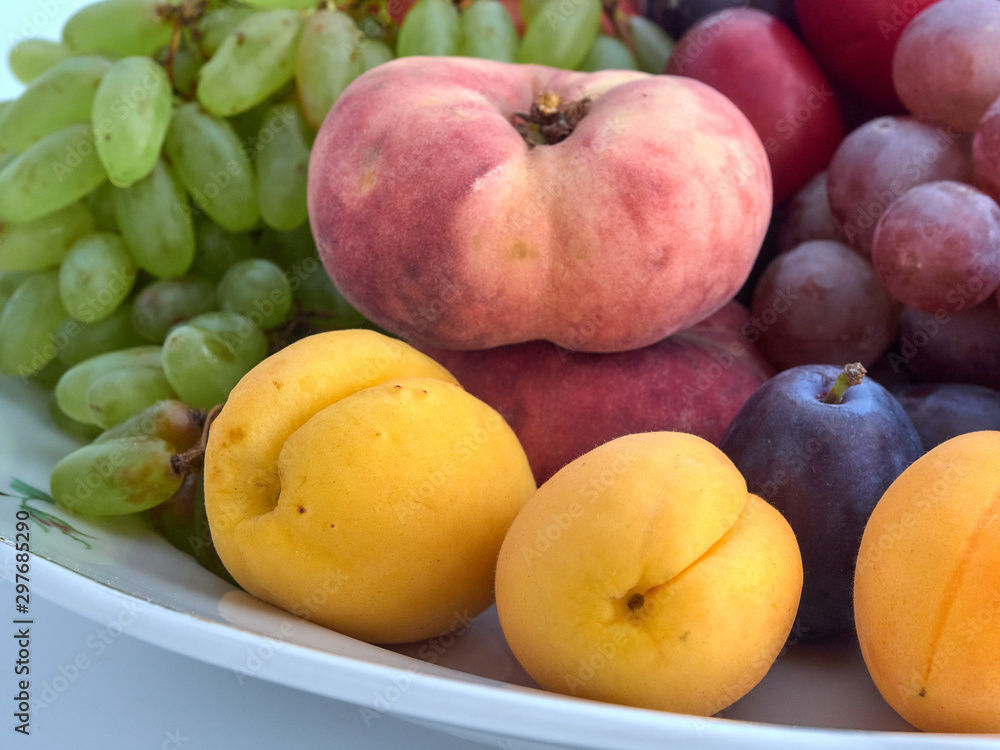 Isolate.Porcelain plate on a white background.On a plate lie juicy ripe fruit Isolate.Porcelain plate on a white background.On a plate lie juicy ripe fruit