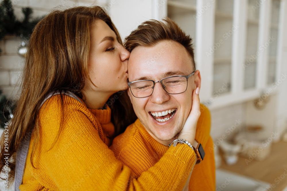 Emotional photo of a happy couple in love. Girl kisses her lover boyfriend - obrazy, fototapety, plakaty 