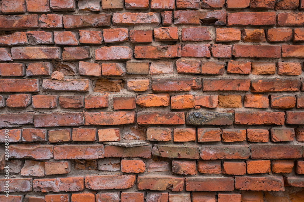 Obraz premium A red brick wall is collapsing. Vintage background