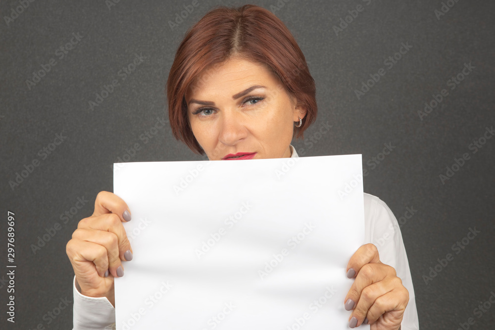 beautiful business woman holding a white sheet of paper in her hands beautiful business woman holding a white sheet of paper in her hands