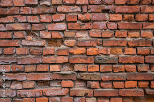 A red brick wall is collapsing. Vintage background