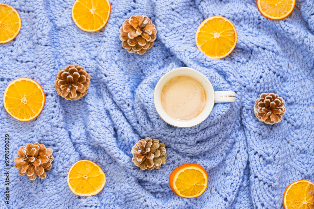 Winter coffee on blue blanket with pine cones and dry oranges. Top view, flat lay Winter coffee on blue blanket with pine cones and dry oranges. Top view, flat lay