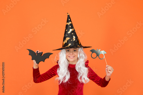 The scariest party tonight. Party girl with Halloween props orange background. Small child wear wicked witch party costume. Halloween kid with party look. Scary holidays. Holiday celebration © be free