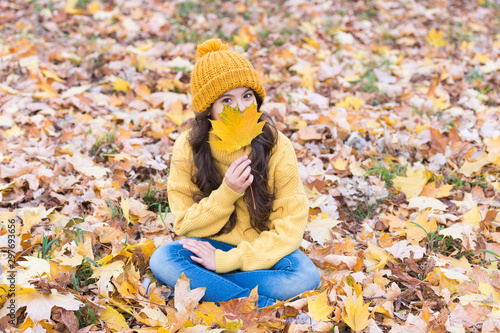 Autumn skin care routine. Kid wear warm knitted hat. Warm woolen accessory. Girl long hair happy face autumn nature background. Keep warmest this autumn. Child in yellow hat outdoors. Lovely season