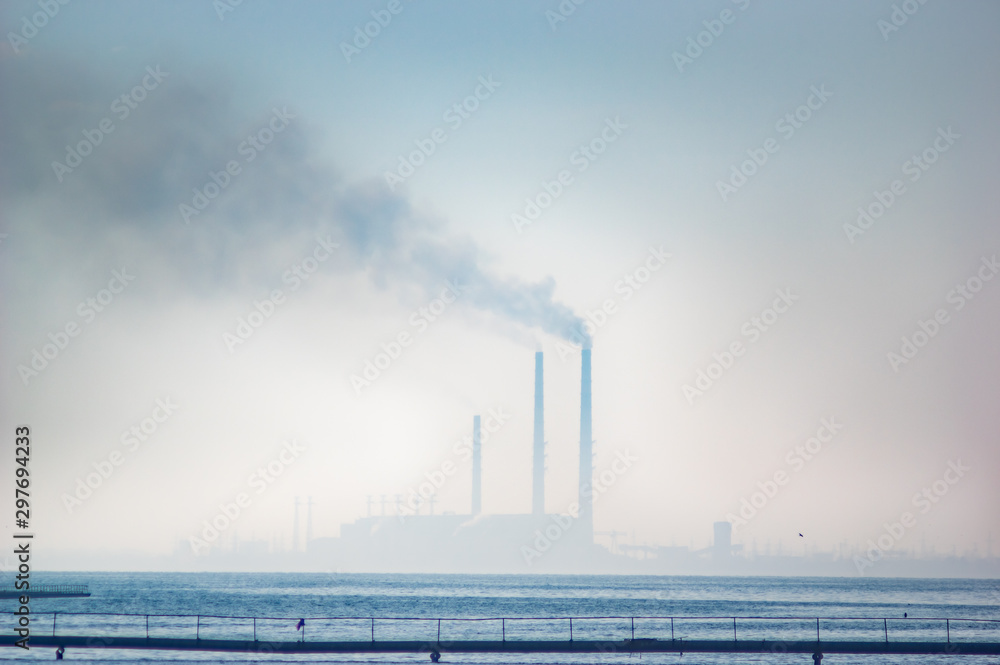 Thermal power plant in a haze on the lake