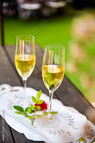 Two glasses of bubbly champagne with unfocused background of a celebration.