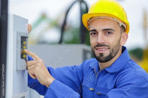 young smiling electrician standing outdoors