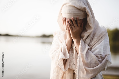Fototapeta Closeup shot of a female wearing a biblical robe crying  - concept confessing si