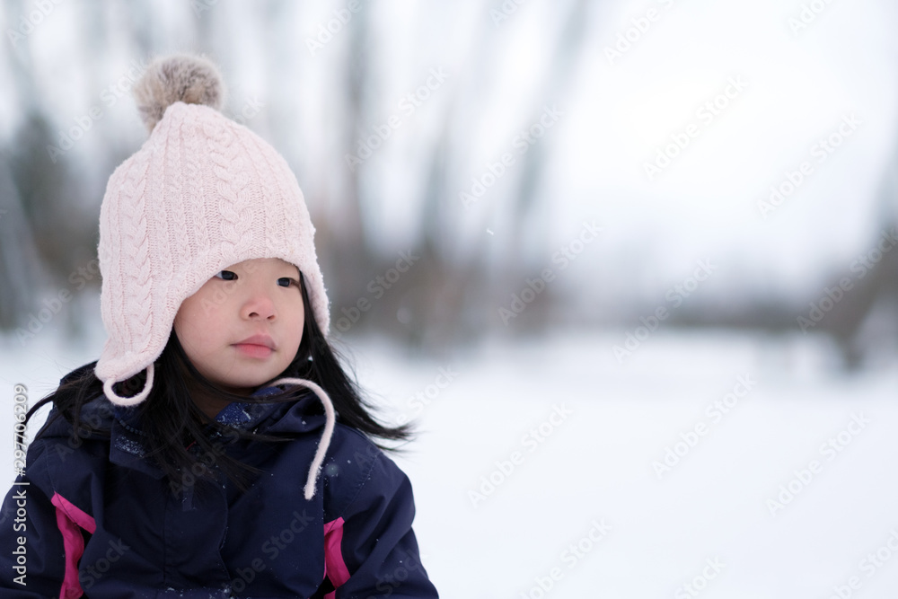 Winter portrait of little asian child girl wearing knitted hat