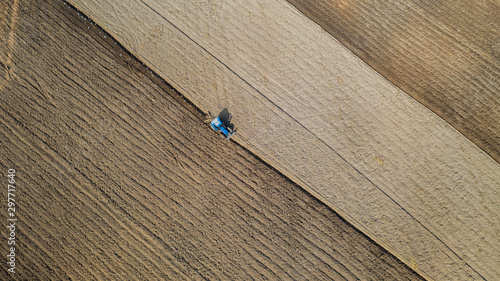 Top view of agricultural tractor vehicles working at field