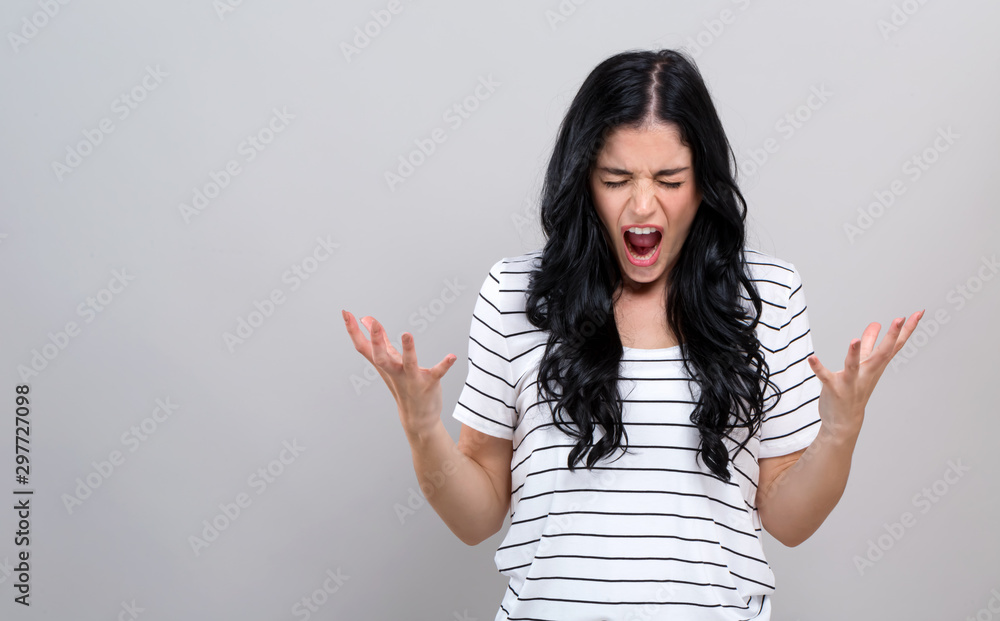 Young woman feeling stressed on a gray background Young woman feeling stressed on a gray background