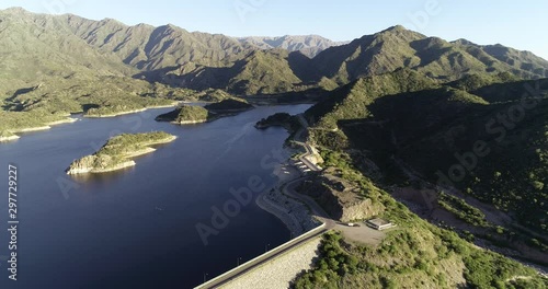 Aerial drone scene of panoramic view of dam with its lake. Flying following road surrounding lake. Background of mountains. Nogoli, San Luis, Argentina photo
