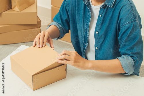 Young man packing parcels for delivery