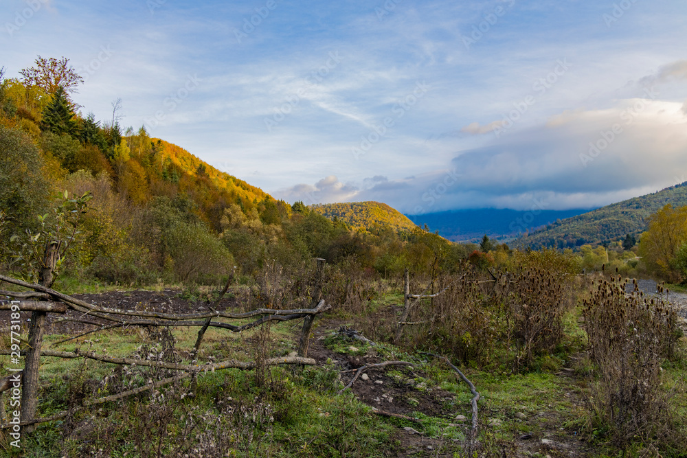 autumn season dramatic view rural country side highland outdoor valley and pasture territory fenced by poor village wooden palisade 