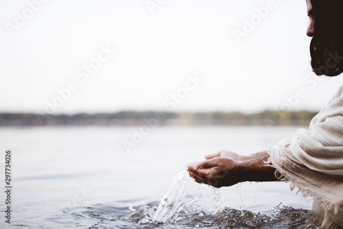 Obraz na plátně Closeup shot of Jesus Christ holding water with his palms