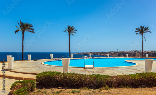 Tropical palm tree resort at swimming pool landscape. © Emoji Smileys People