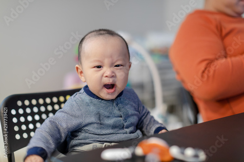 Adorable asian baby sitting on the table, Yawning baby