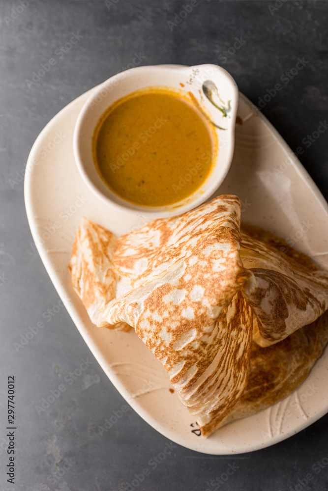 Malaysian Indian cuisine Roti Prata bread with curry dipping sauce