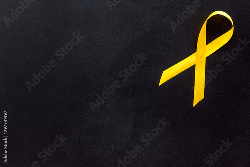 Disease control concept. Yellow ribbon on black background top view space for text