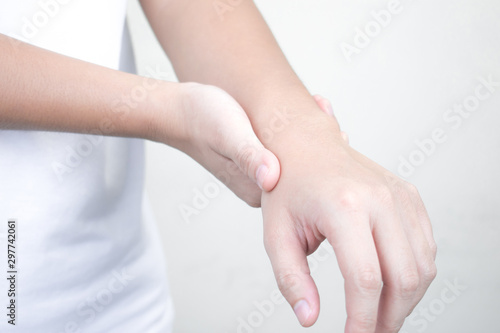 Close-up of Asian hand pain and wrist pain and suffering from wrist pain from work.Office syndrome.