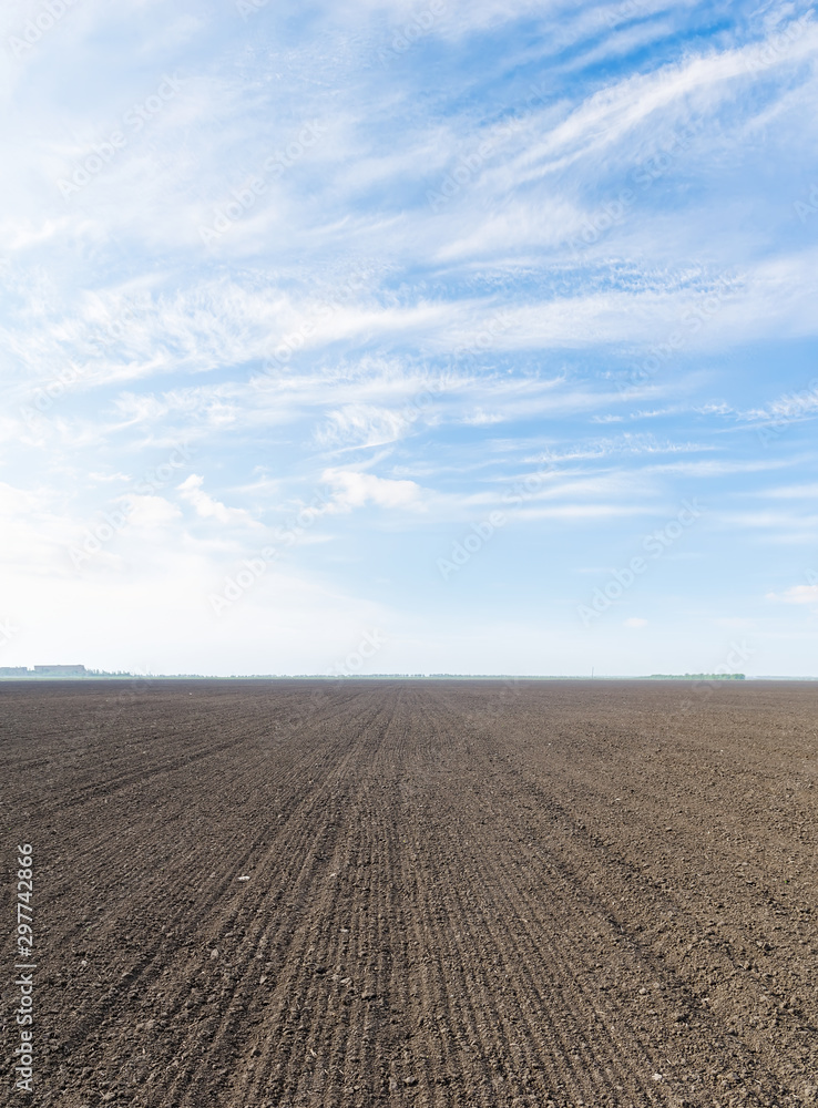 black agriculture field and blue sky with clouds